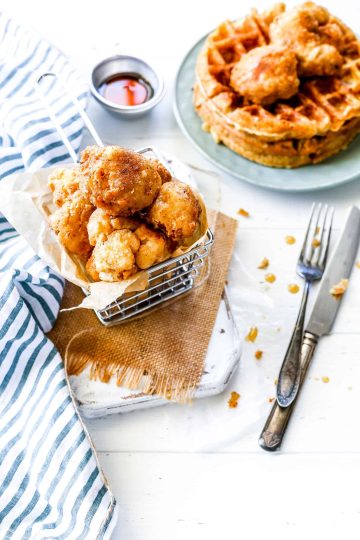 Chicken fried cauliflower in a basket and Belgian waffles.