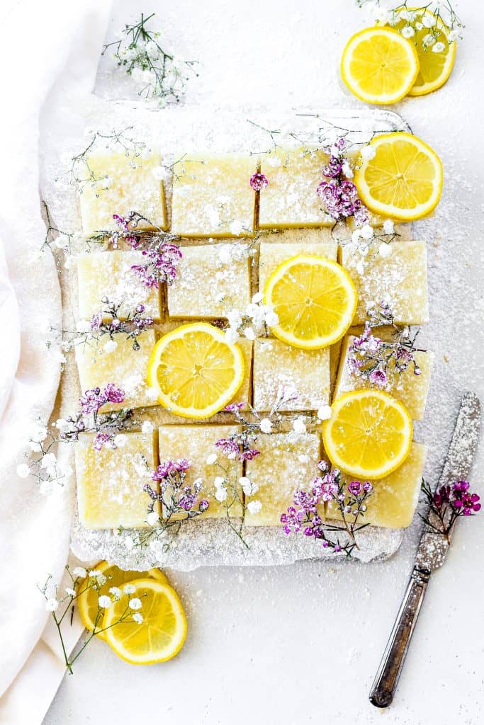 Vegan Lemon Drop Bars next to a knife and a linen.