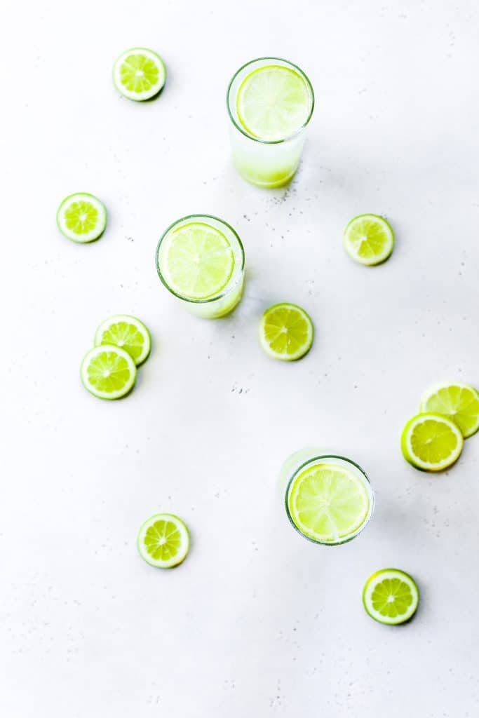 Three midnight rain mocktails surrounded by lime slices.