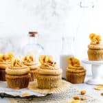 Peanut butter banana cupcake on a cooling rack with paper wrapper peeled back.