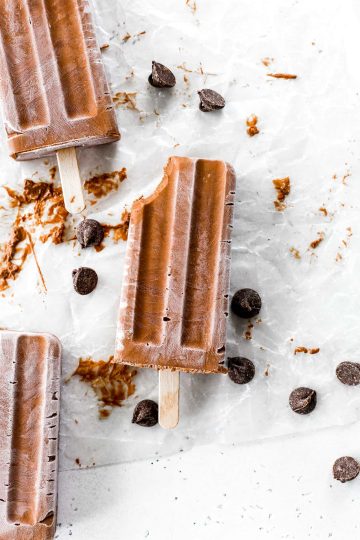 Three vegan fudge pops, one with a bite taken out of it.