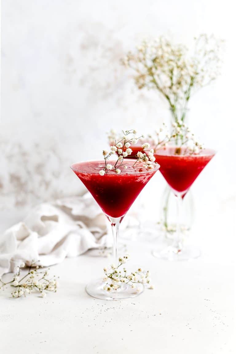 Three "Labyrinth" mocktails in martini glasses topped with white flowers.