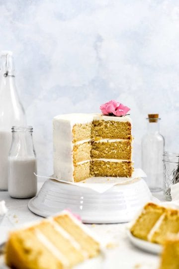 Vegan vanilla cake cut open for a view of the cake layers and frosting.