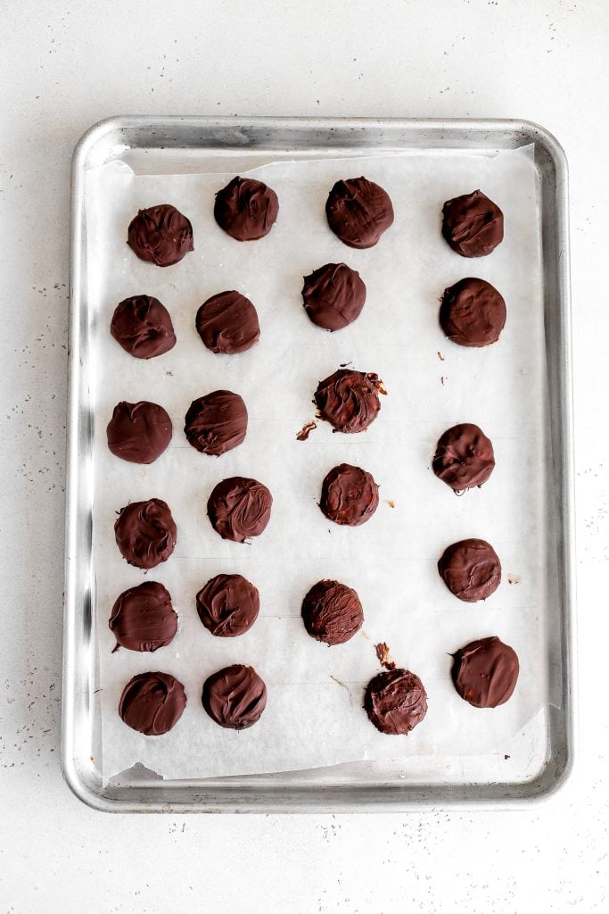 Vegan peppermint patties on a baking sheet lined with wax paper.