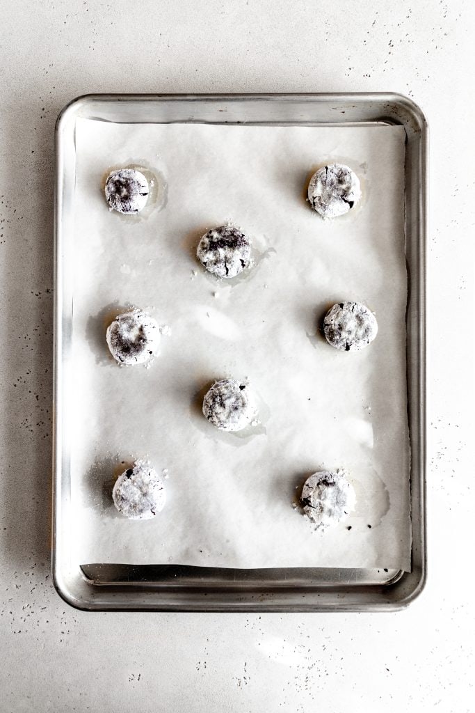 Unbaked vegan chocolate peppermint crinkle cookies on a baking sheet.