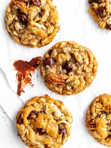 Vegan cowboy cookie on a white surface smeared with melted chocolate.