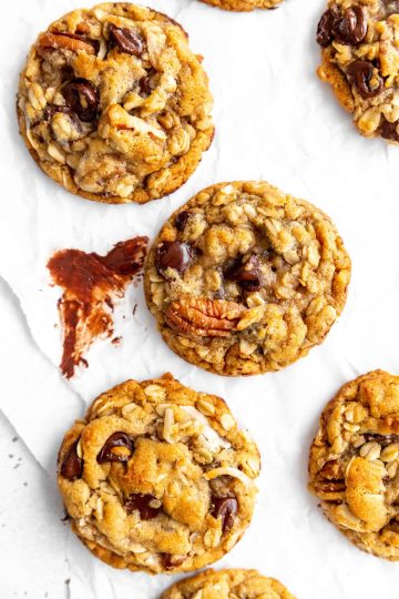 Vegan cowboy cookie on a white surface smeared with melted chocolate.