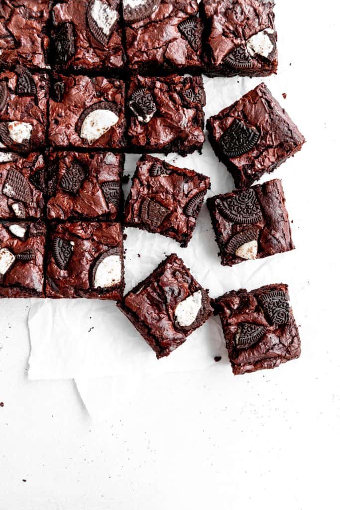 Cut vegan oreo brownies arranged on a white surface.