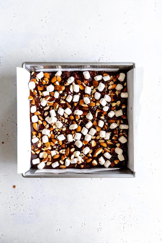 Unset vegan rocky road bars in a square, silver pan lined with parchment paper.