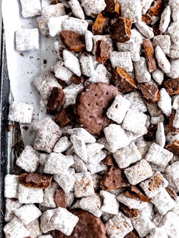 Thin mint muddy buddies spread out on parchment paper.