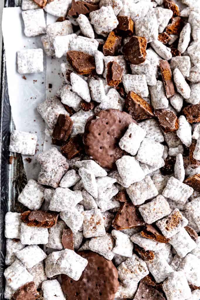 Thin mint muddy buddies spread out on parchment paper.