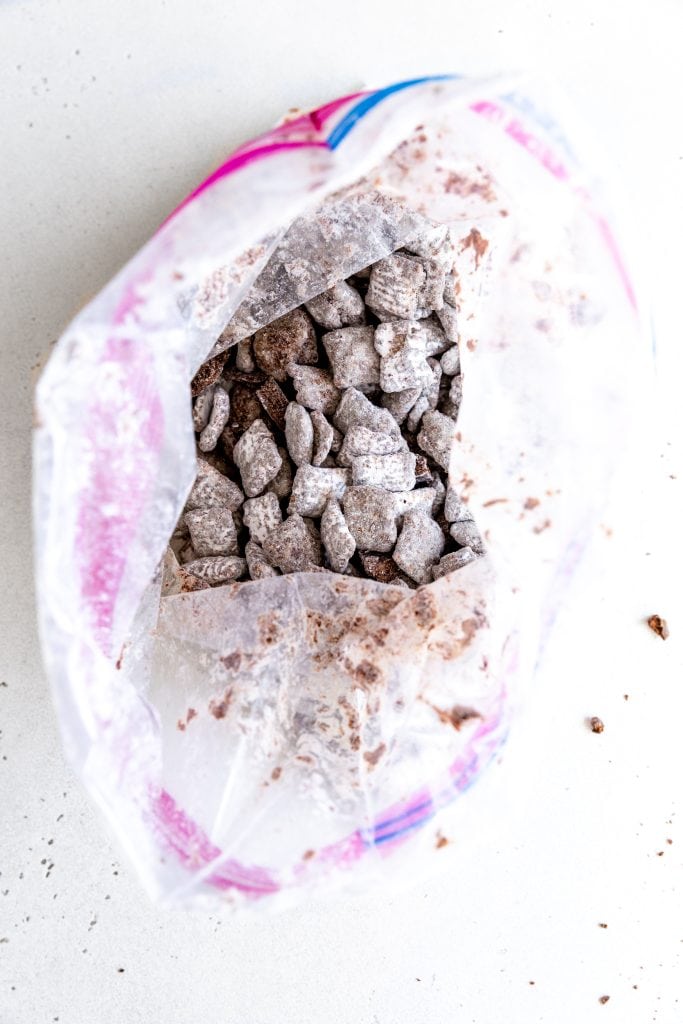 Plastic bag filled with Rice Chex cereal coated in chocolate and powdered sugar.