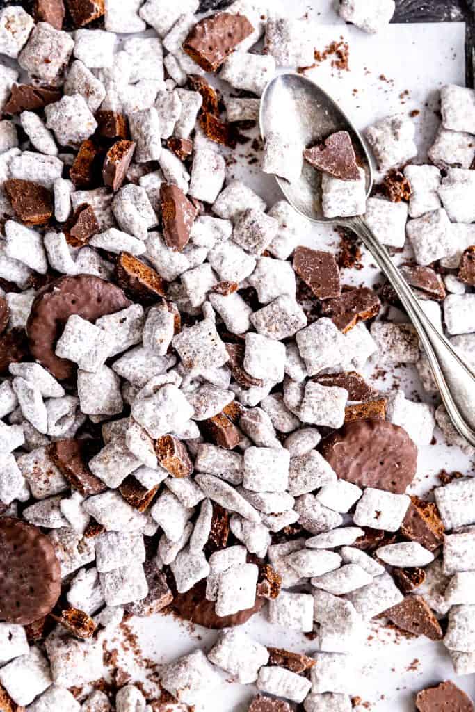 Pile of thin mint muddy buddies on a baking sheet with a silver spoon.