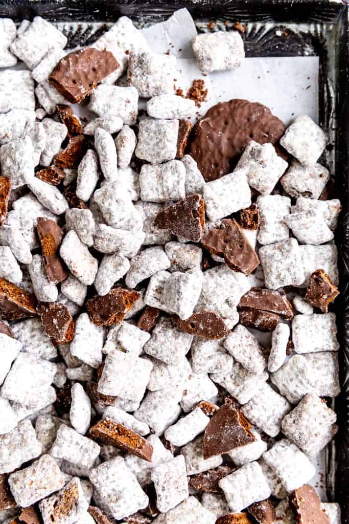 Muddy buddies mixed with thin mint cookies on a baking sheet lined with parchment paper.