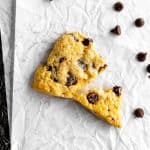 Vegan chocolate chip scone broken in half on baking sheet.