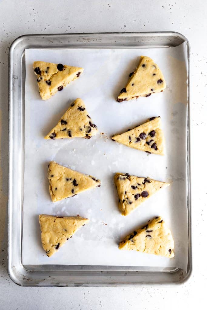 Unbaked vegan chocolate chip scones on a baking sheet.