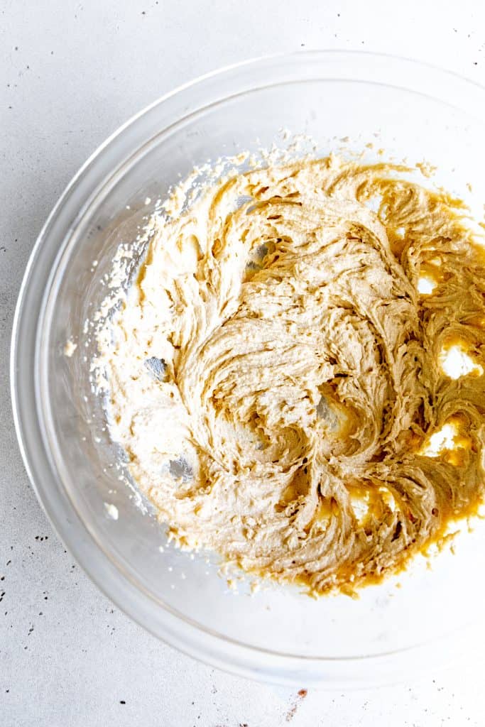 Glass bowl filled with butter and sugar that have been creamed together.