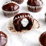 Vegan hostess cupcake with a bite taken out of it showing the cream inside.