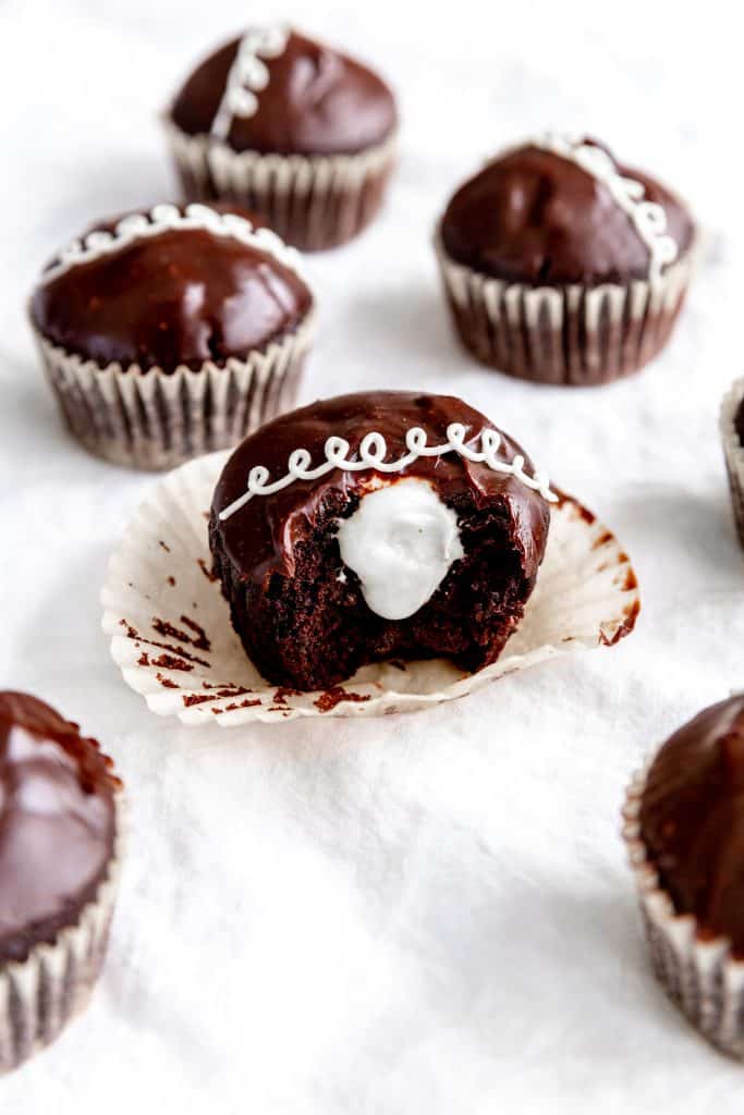 Vegan hostess cupcake with a bite taken out of it showing the cream inside.