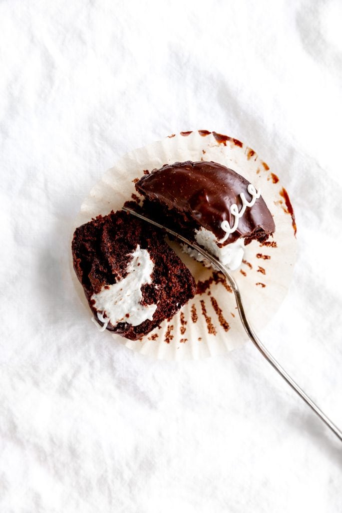 Fork cutting into a vegan hostess cupcake.