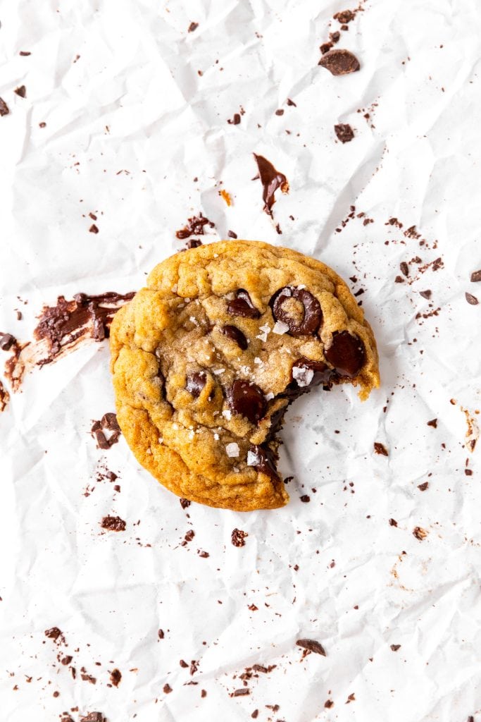 Vegan banana chocolate chip cookie with a bite taken out of it.