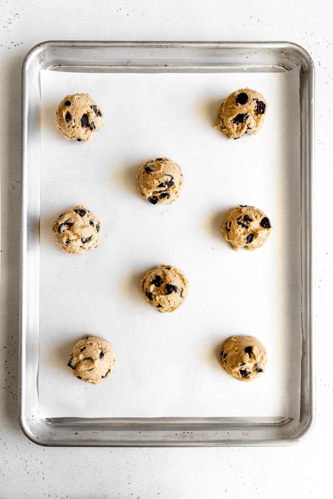 Unbaked banana chocolate chip cookies on a baking sheet.