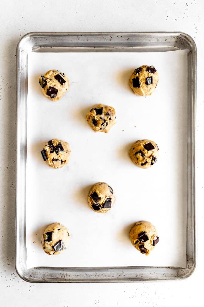 Unbaked chocolate chip cookies on a baking sheet.