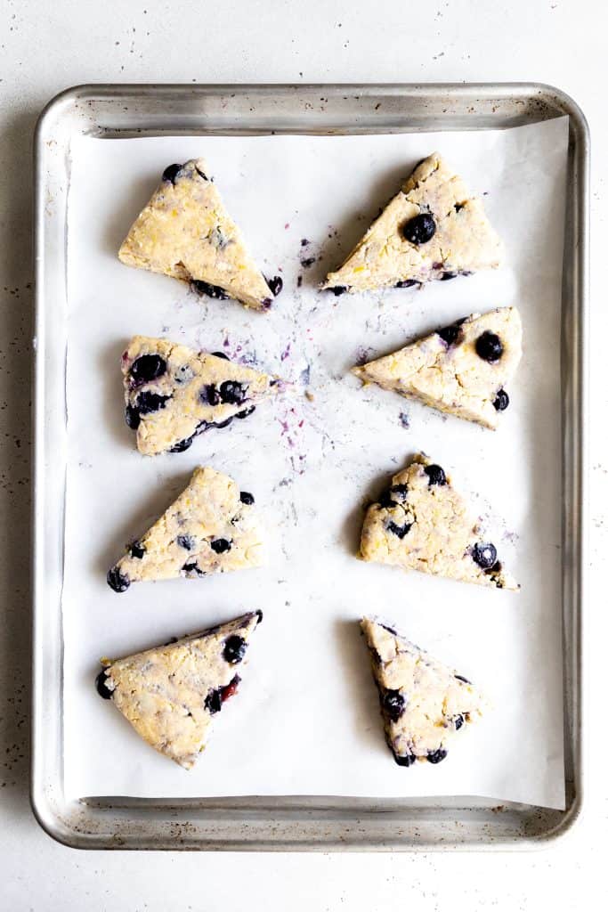 Unbaked lemon blueberry scones on a baking sheet.