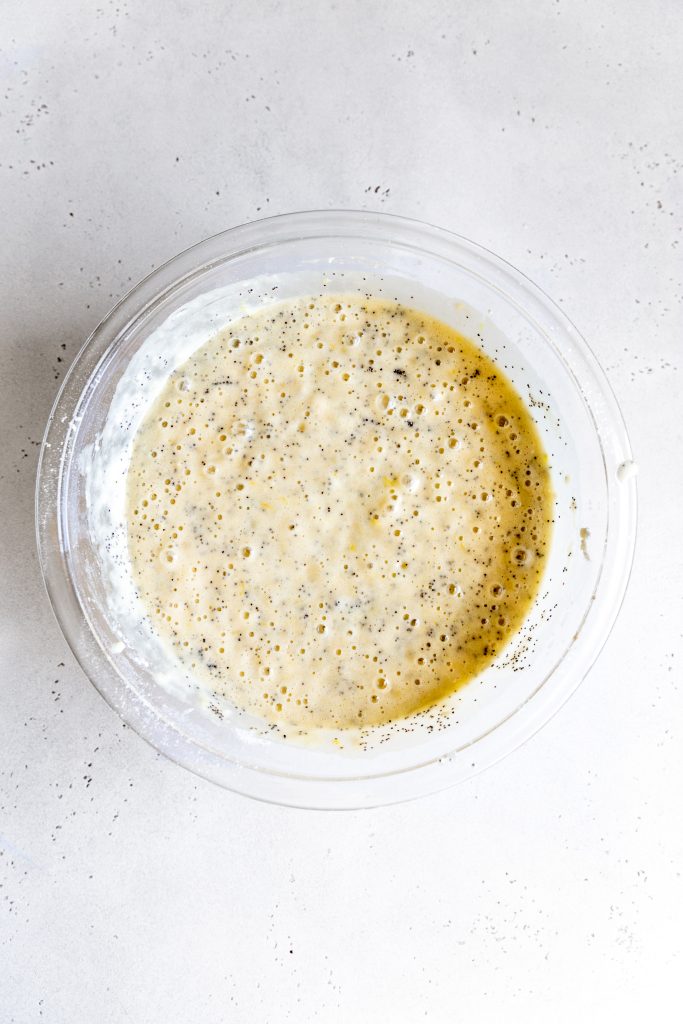 Glass bowl filled with lemon poppyseed cake batter.