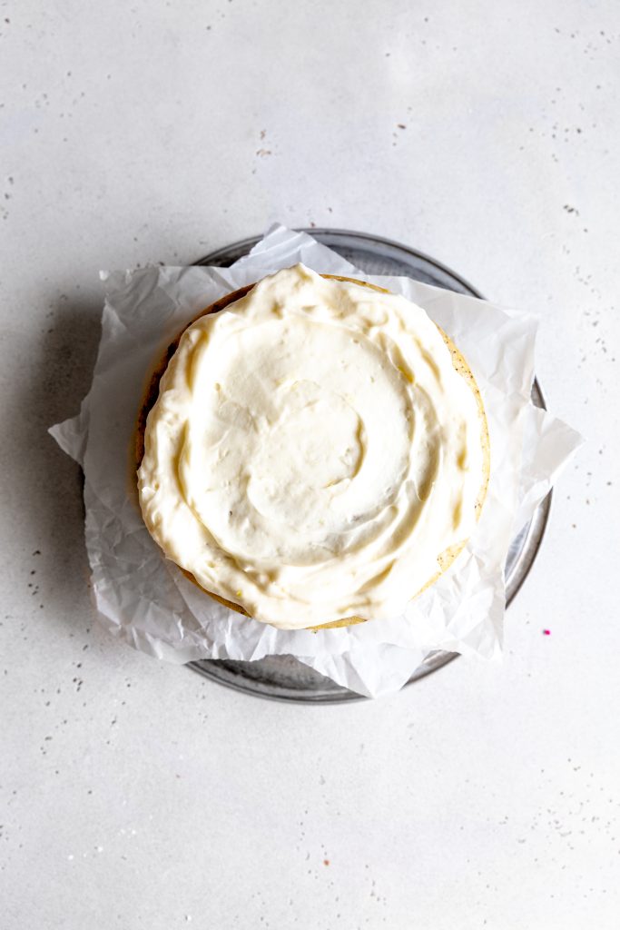 Frosted cake layer with a shallow well of frosting in the center.