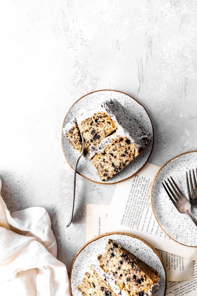 Fork cutting into a slice of Oreo cake on a white plate.