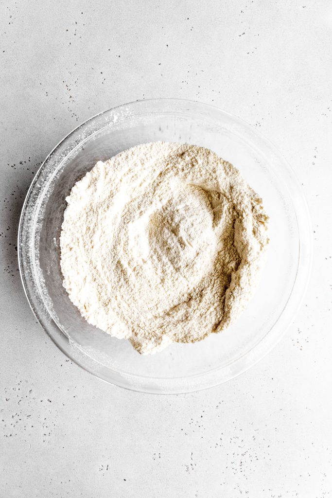 Glass bowl filled with the dry ingredients for vanilla cake.