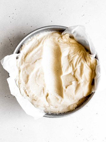 Round pan of vanilla ice cream with a scoop missing.