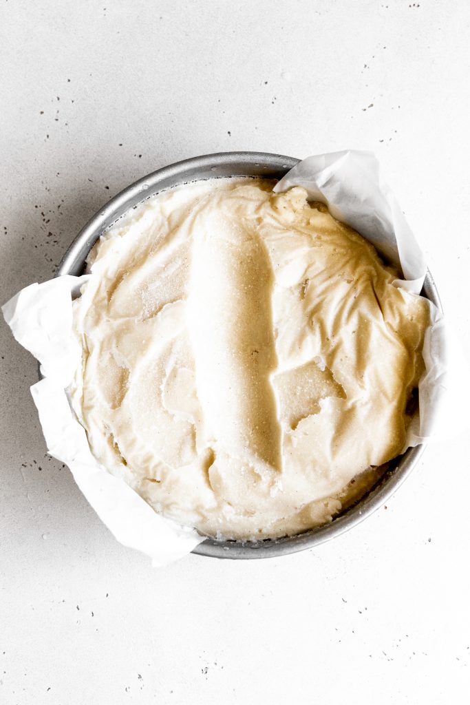 Round pan of vanilla ice cream with a scoop missing.