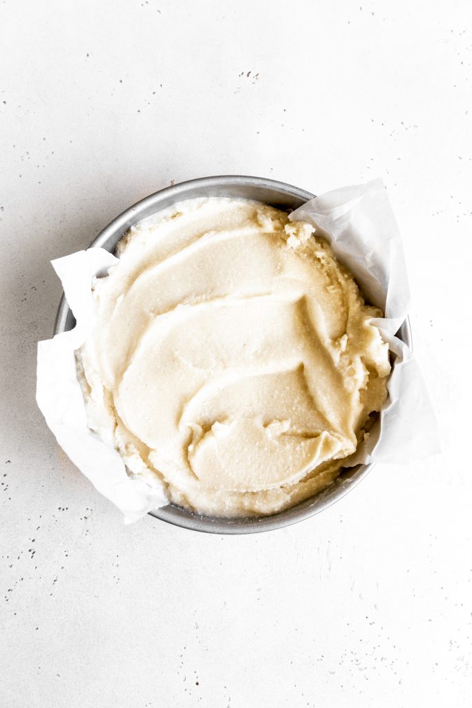 Vanilla ice cream base in a round cake pan lined with parchment paper.