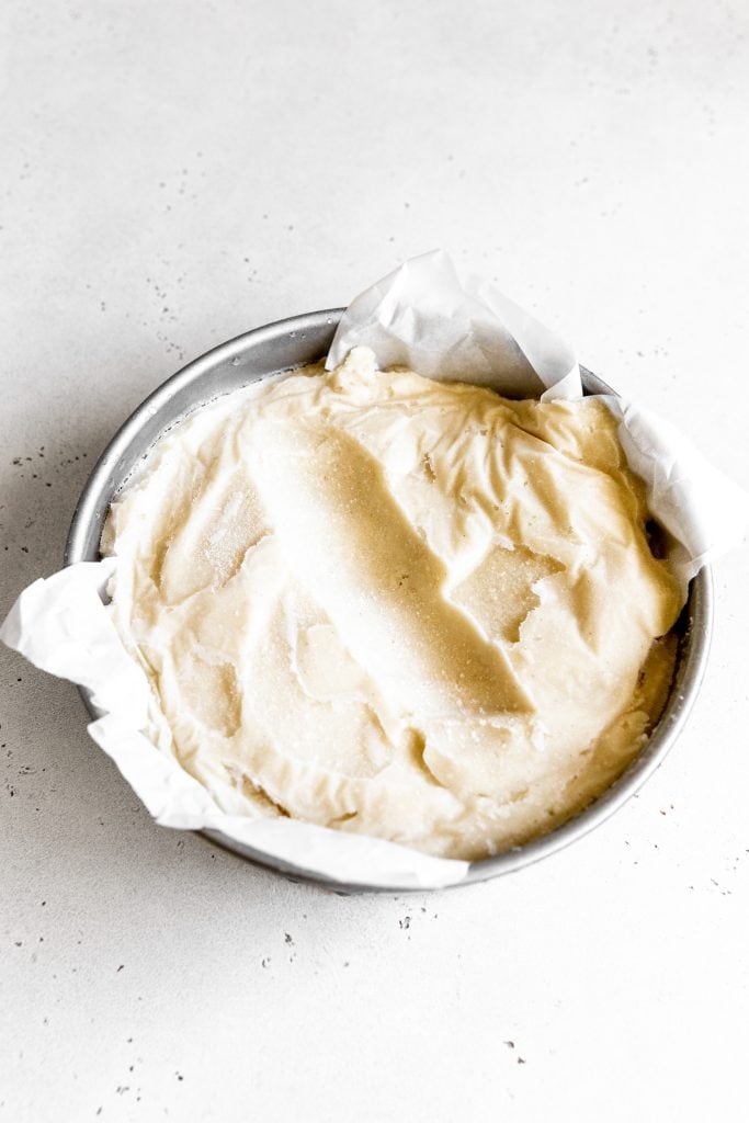 Round pan of vanilla ice cream with a scoop missing.