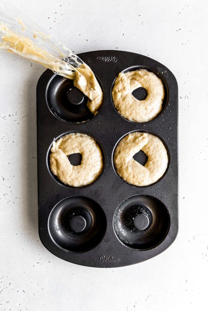 Unbaked vegan donuts in a baking pan.