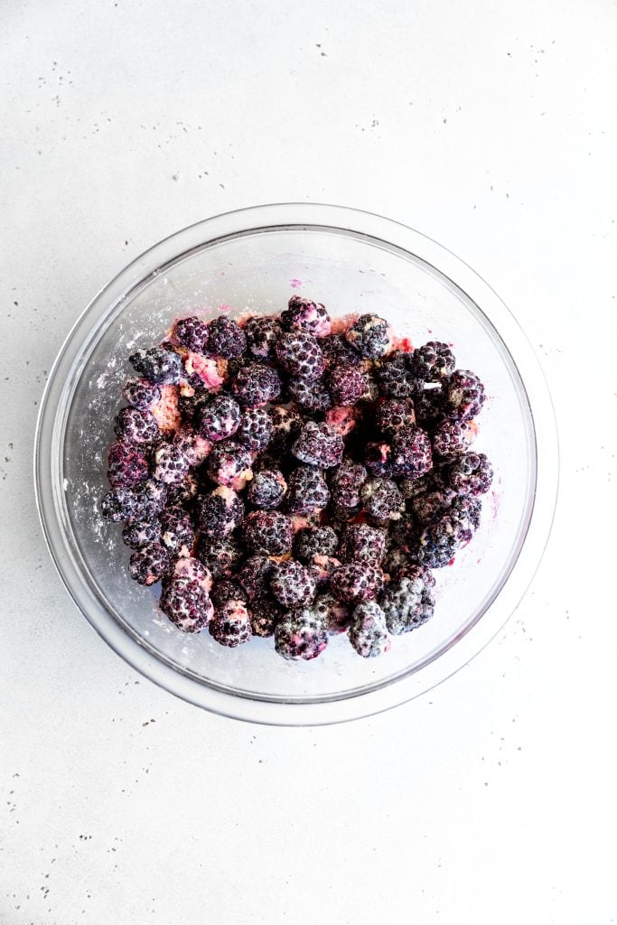 Glass bowl filled with frozen blackberries.