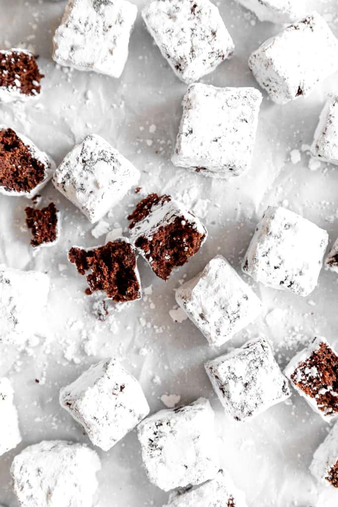 Brownie bite broken in half on a baking sheet with more brownie bites.