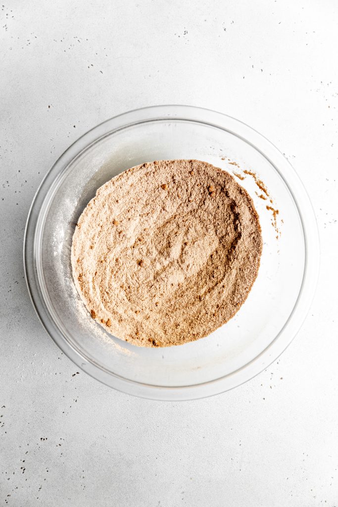 Glass bowl filled with dry brownie batter ingredients.