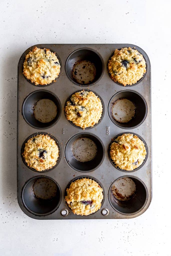 Baked lemon blueberry muffins in a cupcake pan.