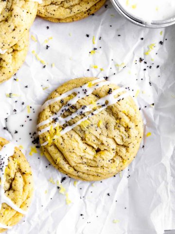 Lemon poppy seed cookie drizzled in glaze on parchment paper.