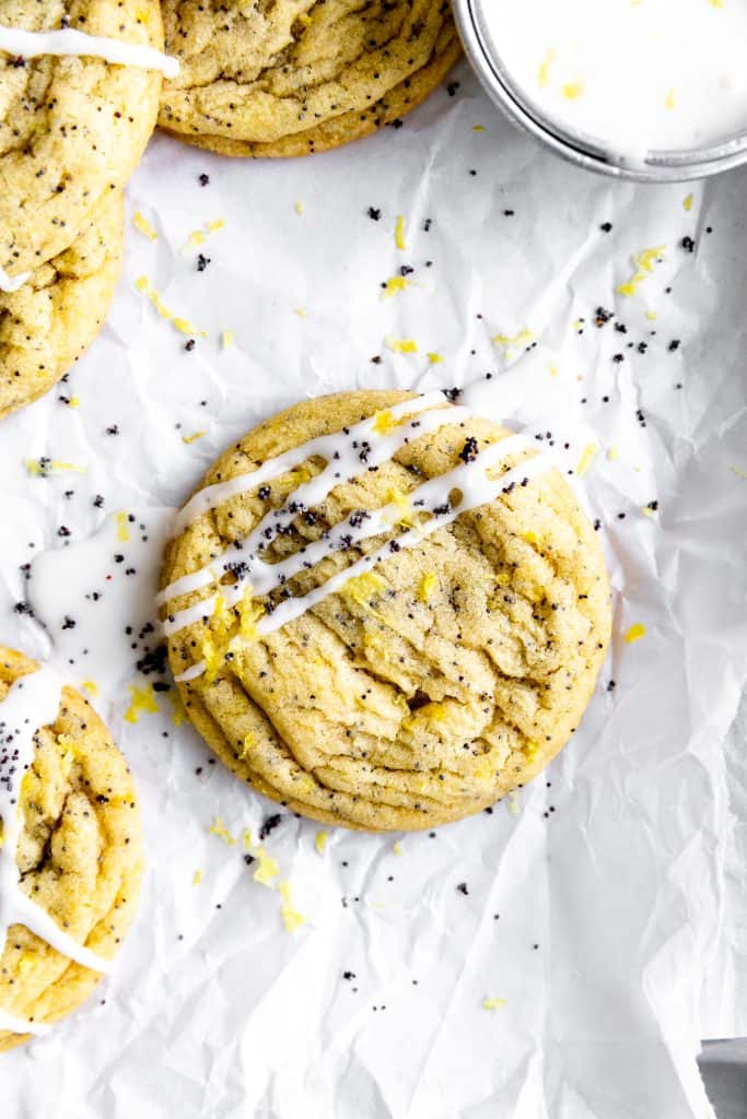 Lemon poppy seed cookie drizzled in glaze on parchment paper.