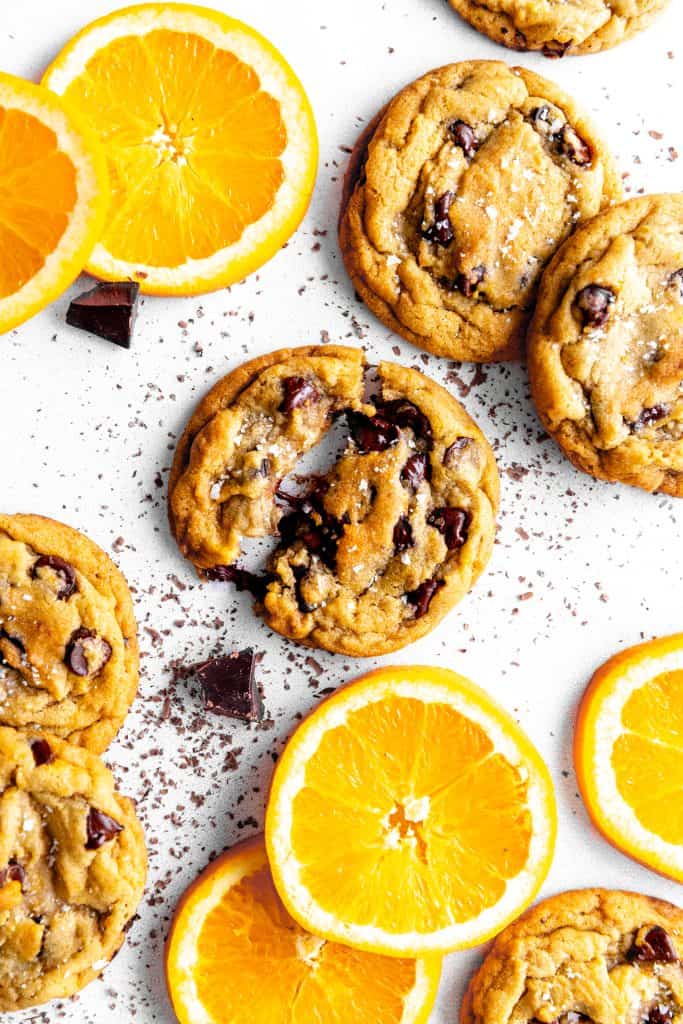 Orange chocolate chip cookie split in half and orange slices.