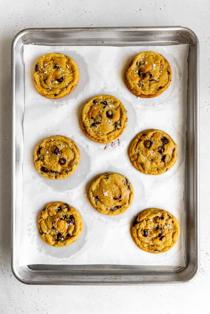 Baked orange chocolate chip cookies on a baking sheet.