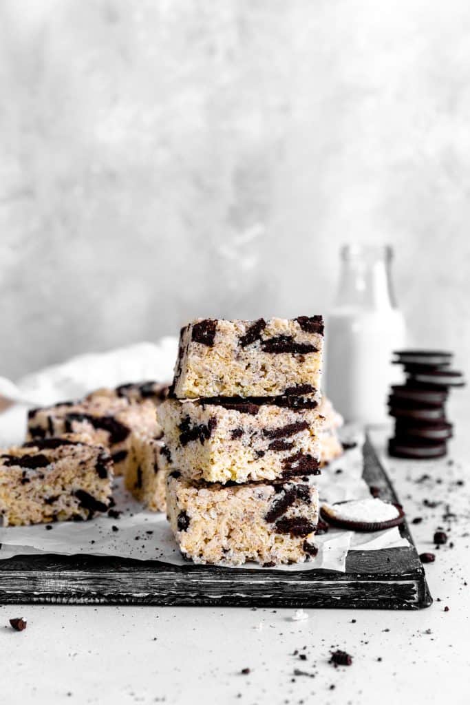 Stack of oreo rice krispie treats in front of a jug of milk.