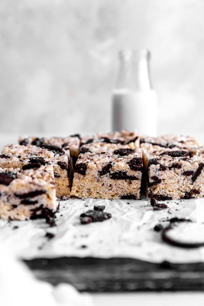 Side view of oreo rice krispie treats in front of a jug of milk.