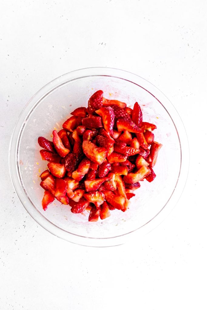 Glass bowl filled with strawberry crisp filling.