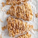 Apple cinnamon scones drizzled in glaze on a white background.