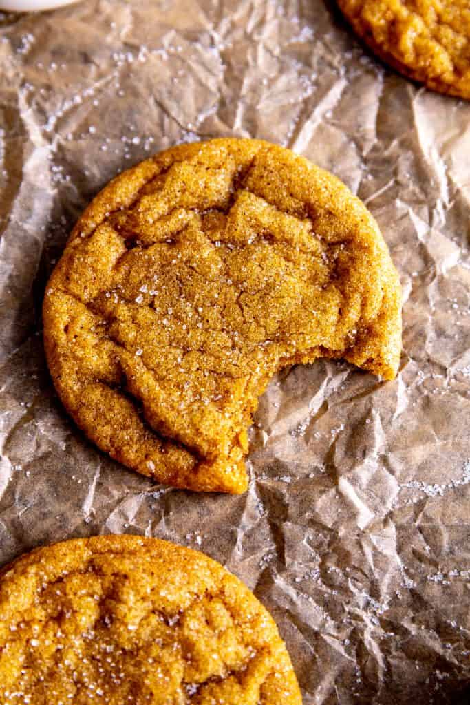 Pumpkin sugar cookie with a bite taken out of it.